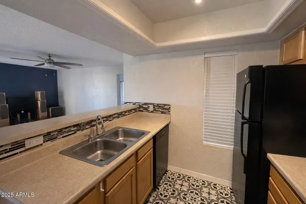 a kitchen that has a sink a refrigerator and a stove top oven