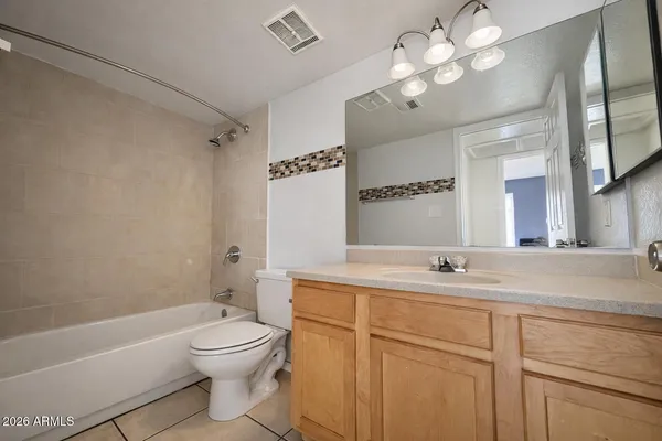 a bathroom with a toilet a sink a mirror a bathtub and vanity