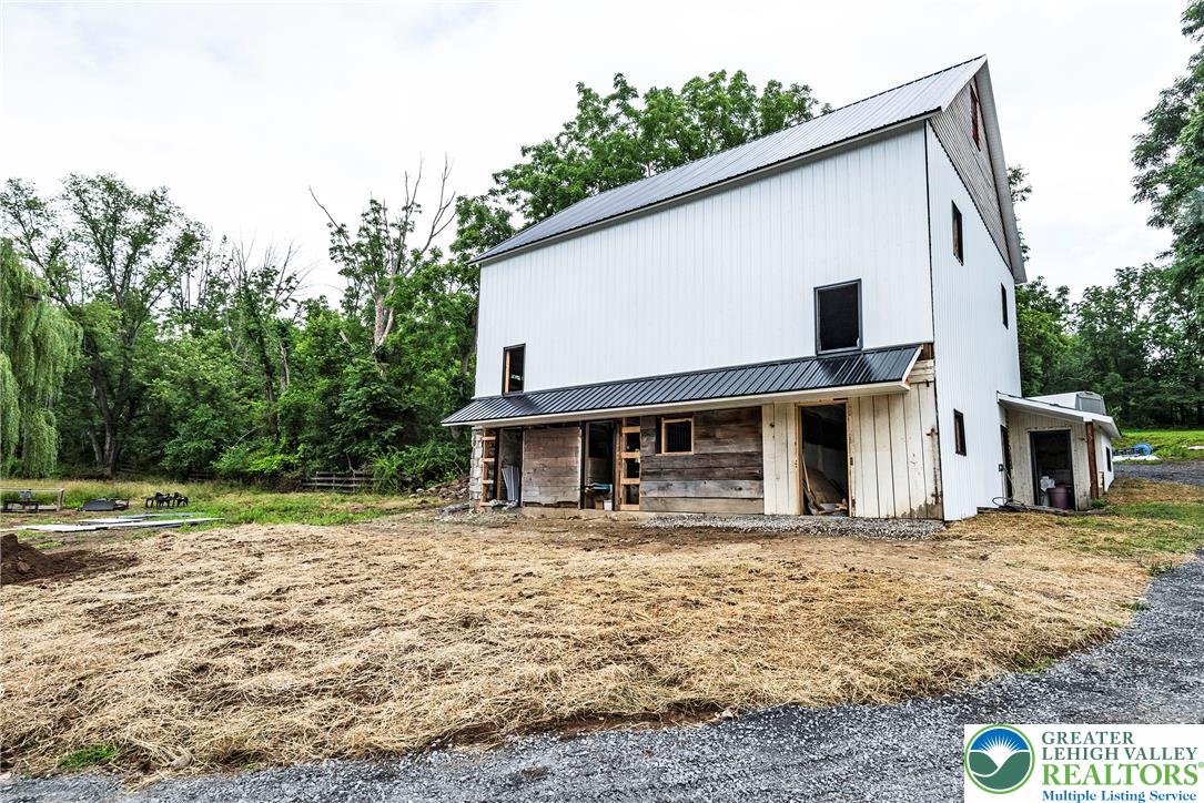 72 Allegheny Road Mount Bethel, PA 18343 - Photo 53 of 72 A striking modern barn-style home emerges from a natural landscape, offering a tranquil rural escape.