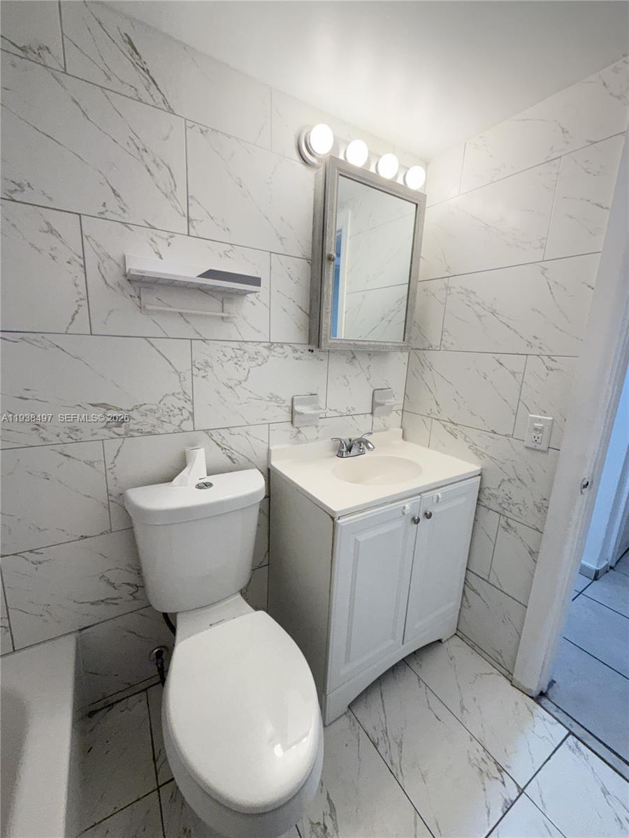 1860 Southwest 22nd Street, Unit 7 Miami, FL 33145 - Photo 3 of 8 a bathroom with a toilet sink and mirror