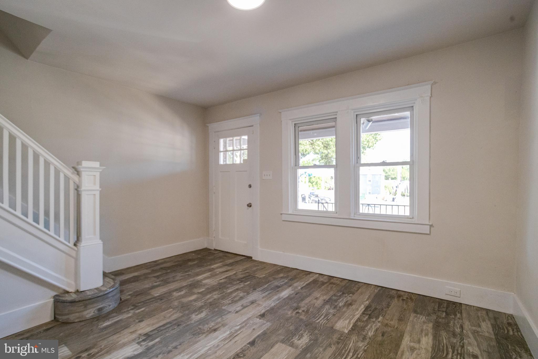 5878 Belair Road Baltimore, MD 21206 - Photo 7 of 41 an empty room with wooden floor and windows