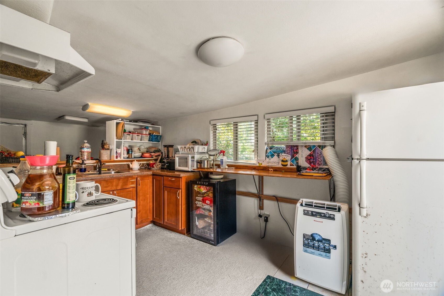 8011 South 128th Street Seattle, WA 98178 - Photo 4 of 15 a kitchen with stainless steel appliances granite countertop a refrigerator a sink dishwasher a stove and a dining table with wooden floor