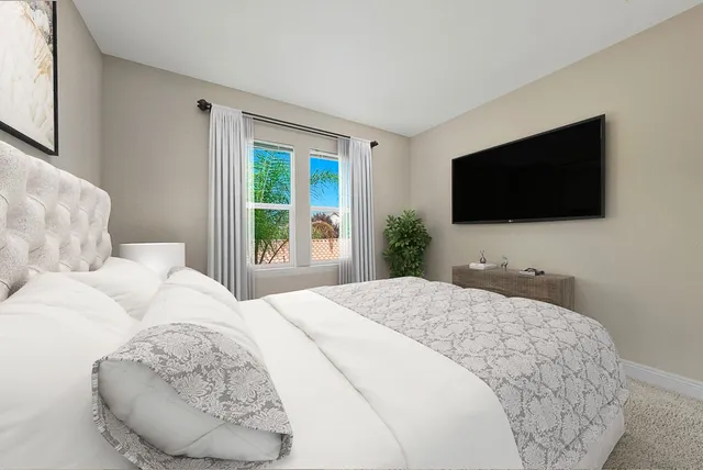 a bedroom with a bed and a flat screen tv