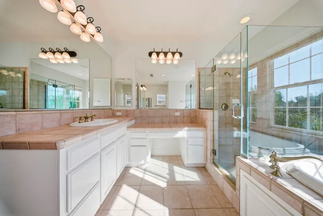 a bathroom with a tub sink and mirror