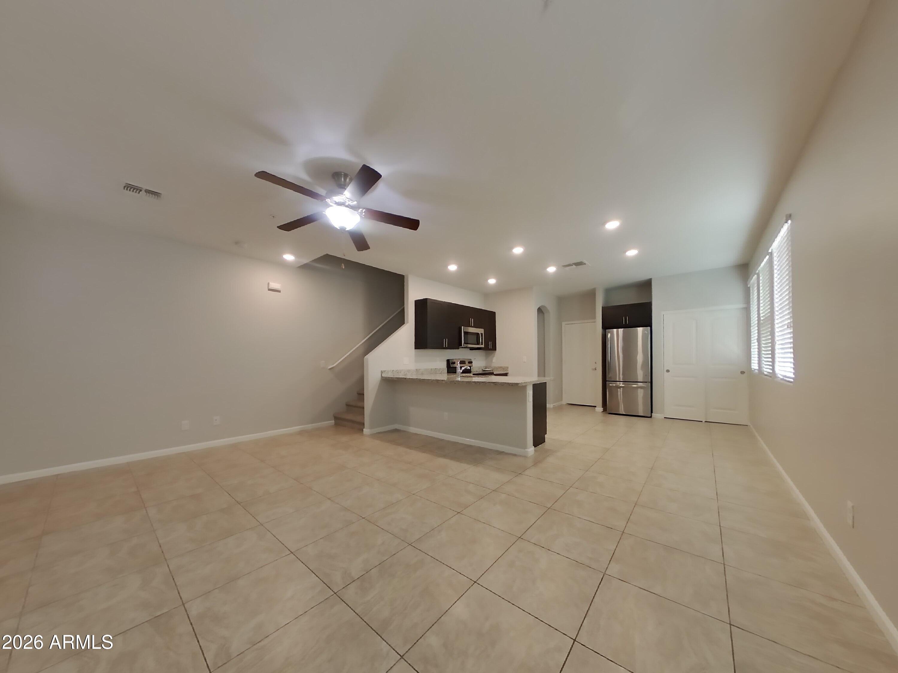 12577 West Steed Ridge Peoria, AZ 85383 - Photo 2 of 17 a living room with furniture and a ceiling fan