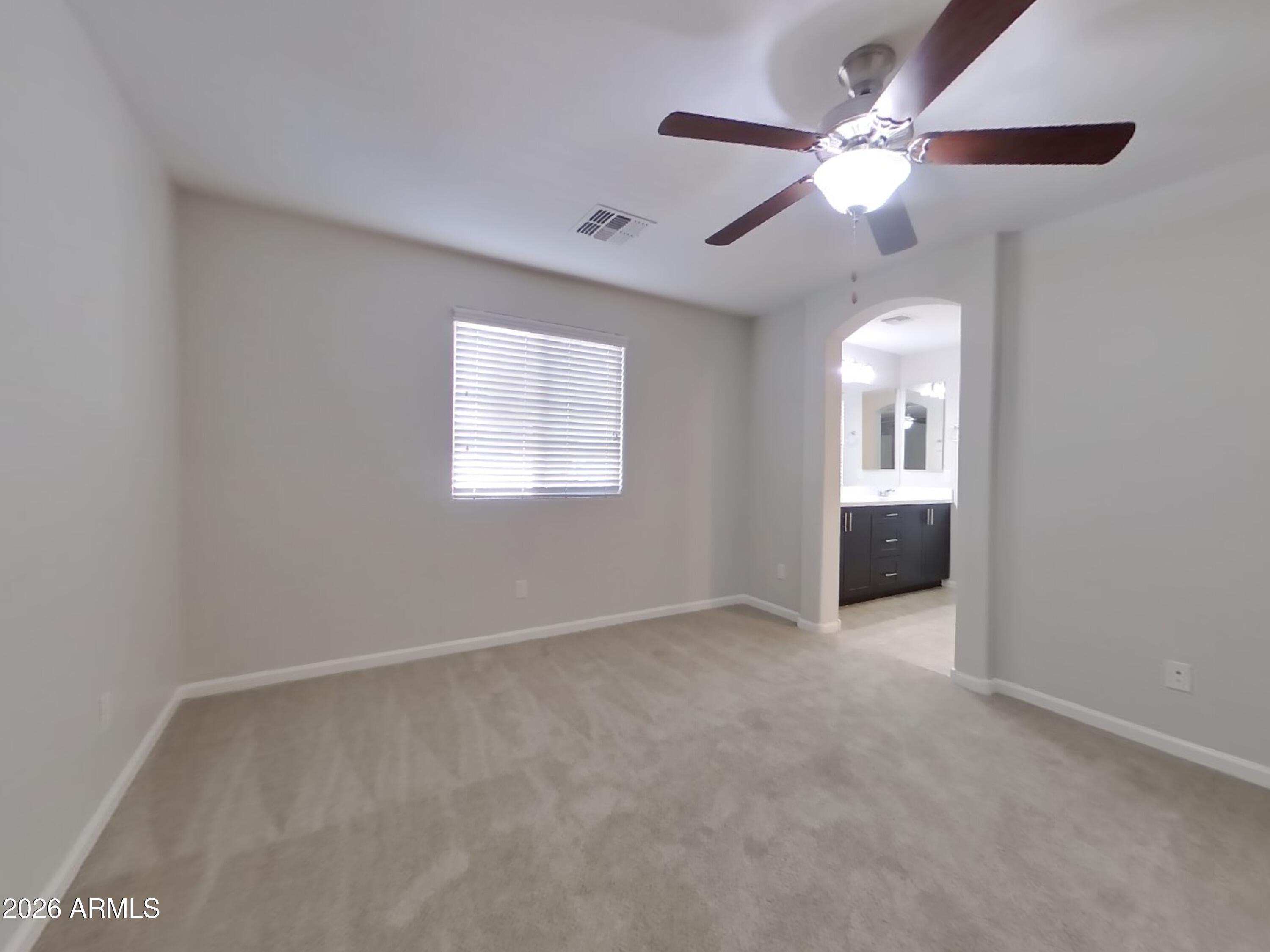 12577 West Steed Ridge Peoria, AZ 85383 - Photo 5 of 17 an empty room with chandelier fan and windows
