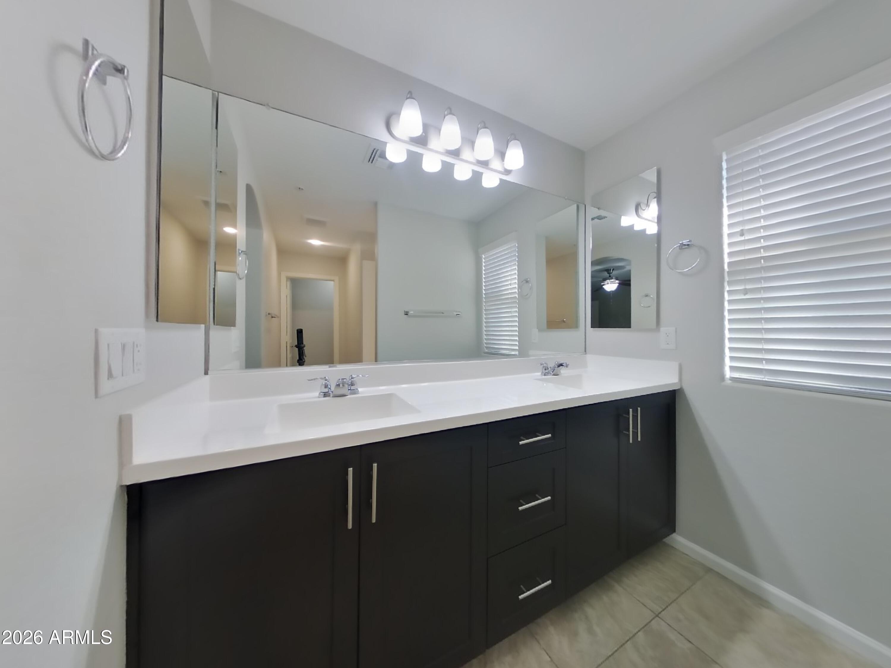 12577 West Steed Ridge Peoria, AZ 85383 - Photo 7 of 17 a bathroom with a sink vanity and a mirror