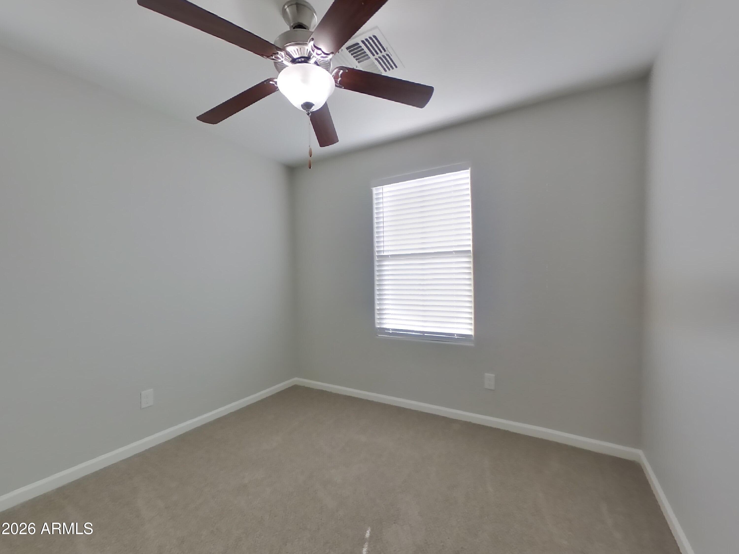 12577 West Steed Ridge Peoria, AZ 85383 - Photo 9 of 17 an empty room with a window and a fan