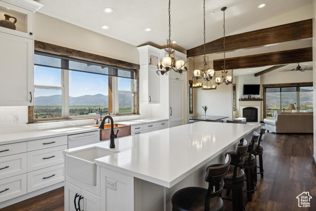 6117 North Rocky Ridge Road Peoa, UT 84061 - Photo 39 of 83 Kitchen with a breakfast bar, sink, a center island with sink, a mountain view, and white cabinets