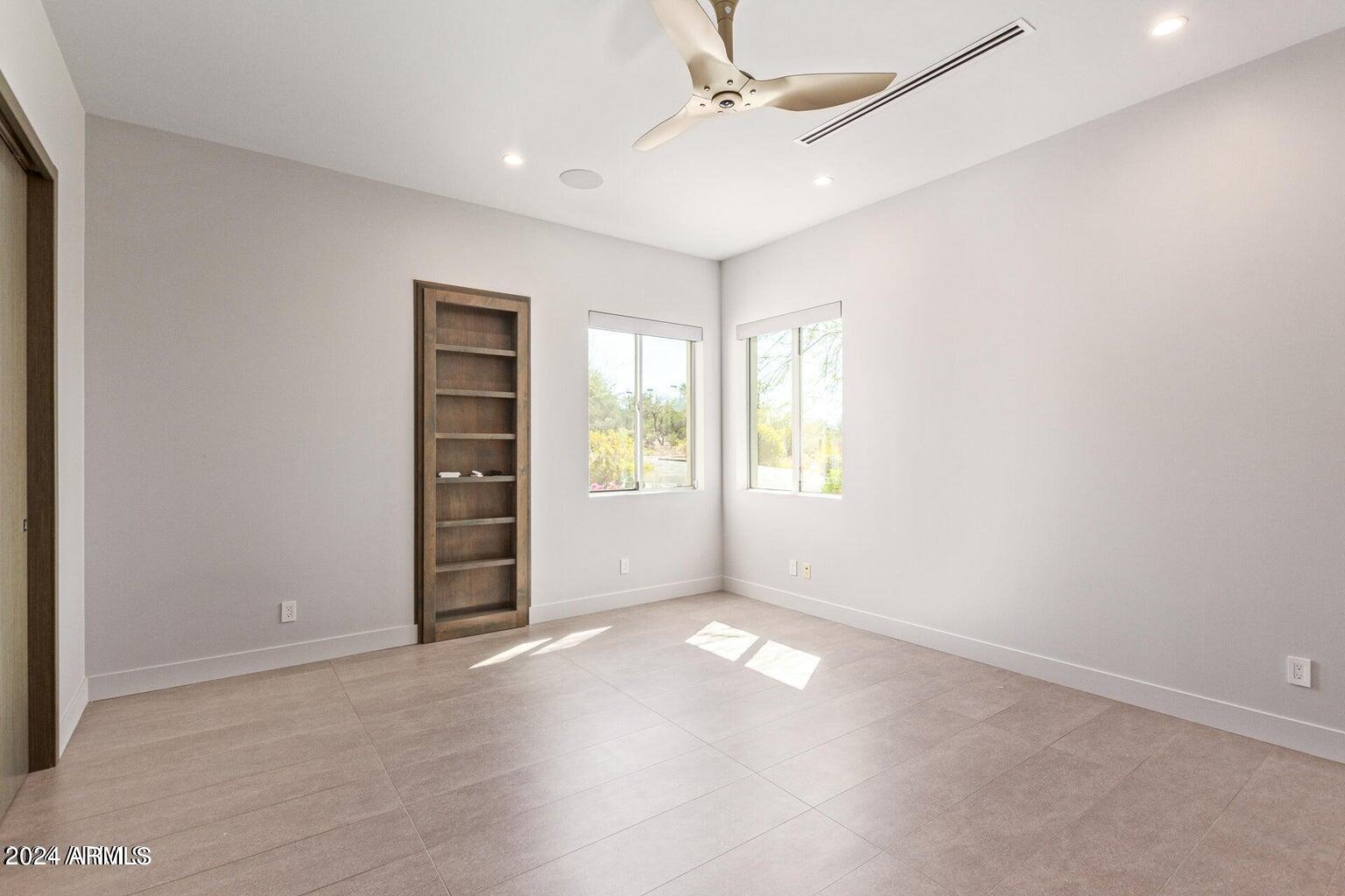 5833 North 46th Street Phoenix, AZ 85018 - Photo 21 of 29 an empty room with windows and ceiling fan