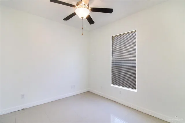 an empty room with a window and a fan