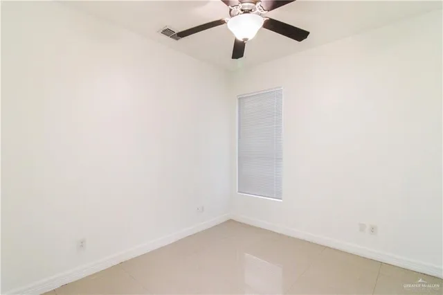 an empty room with a window and a fan