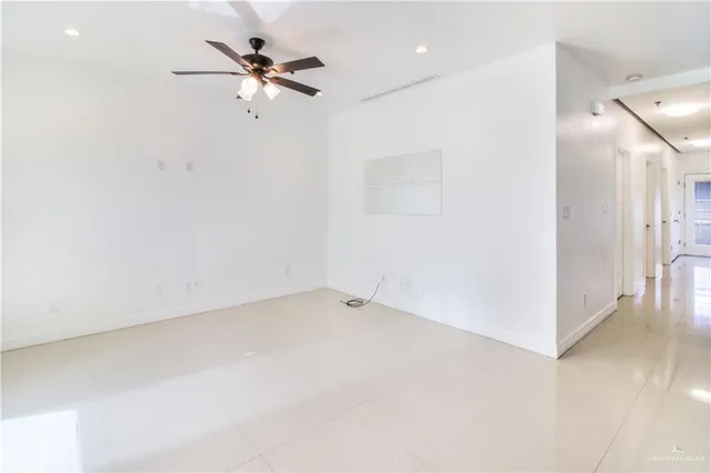 an empty room with a ceiling fan and a window