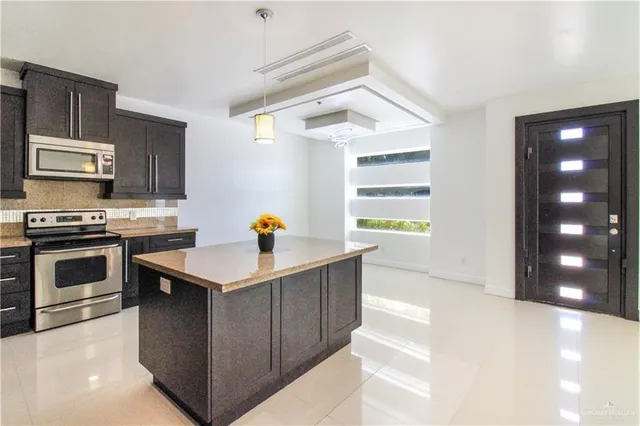 a kitchen with stainless steel appliances a stove a sink and a microwave