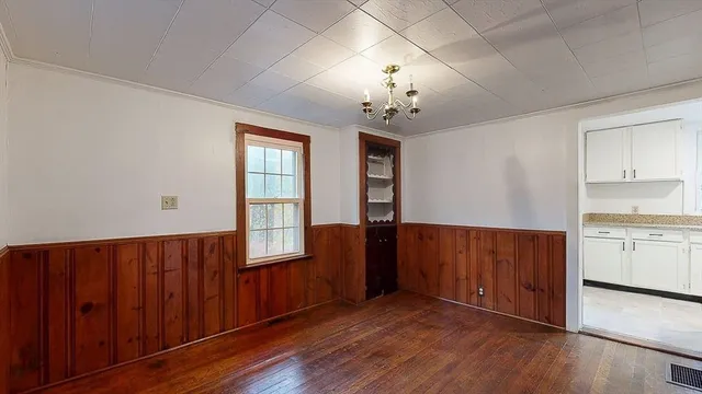 an empty room with wooden floor and window