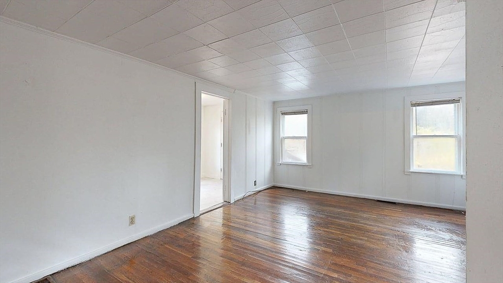 450 Mt Wayte Avenue Framingham, MA 01702 - Photo 15 of 28 an empty room with wooden floor and windows