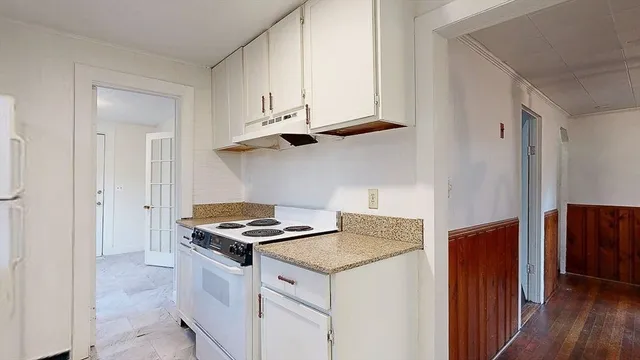 a kitchen with stainless steel appliances cabinets and wooden floor