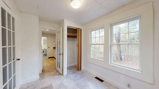 an empty room with windows and closet