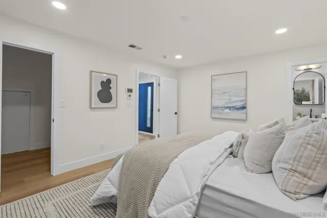 a bedroom with a large bed and a wooden floor