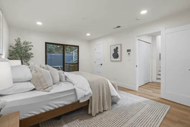 a bedroom with a large bed and a wooden floor