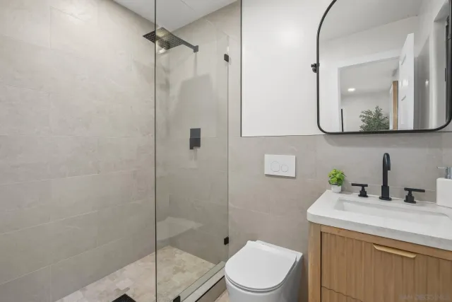a bathroom with a toilet sink vanity and mirror