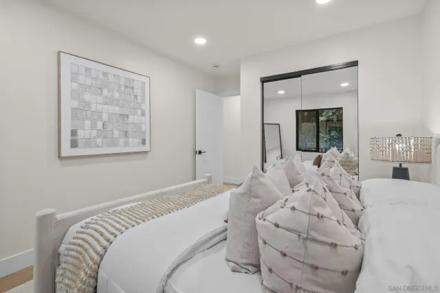 a bedroom with a large bed and a large mirror