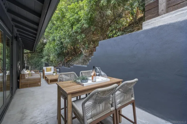 a terrace with a table and chairs and potted plants