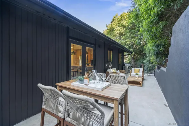 a view of a patio with table and chairs and couches with wooden floor and fence