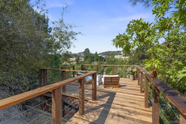 a view of a balcony with wooden floor and fence