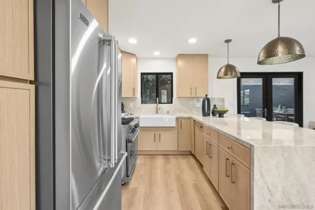 a large white kitchen with a sink a refrigerator and a stove
