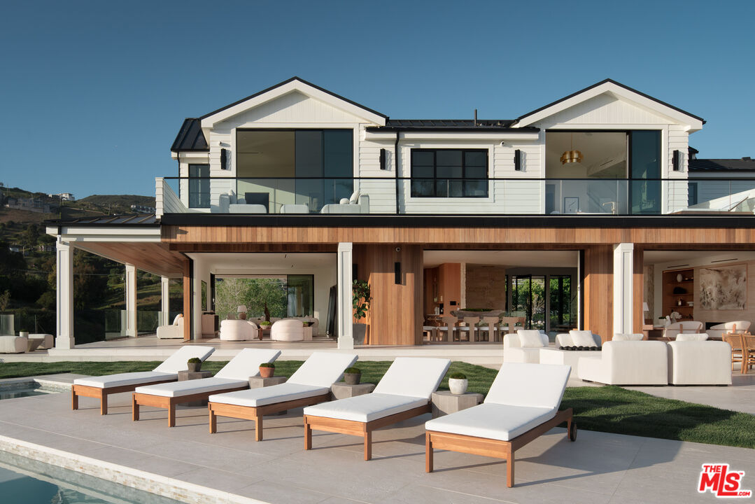 5819 Filaree Heights Road Malibu, CA 90265 - Photo 16 of 41 a view of a patio with couches table and chairs with floor to ceiling window