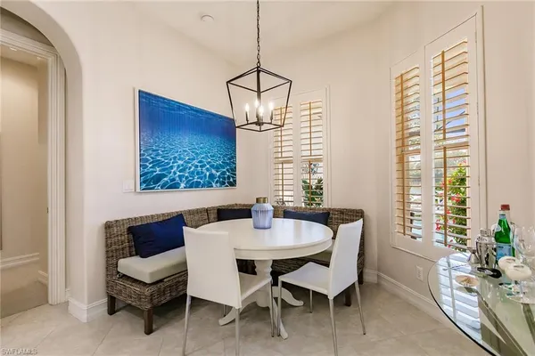 a dining room with furniture a chandelier and window
