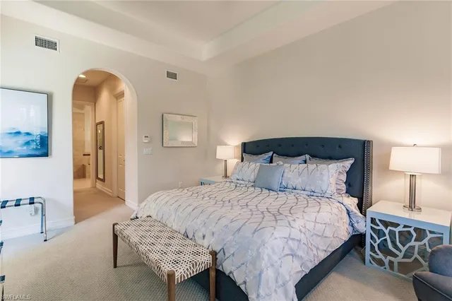 a bedroom with a bed a mirror and lamp