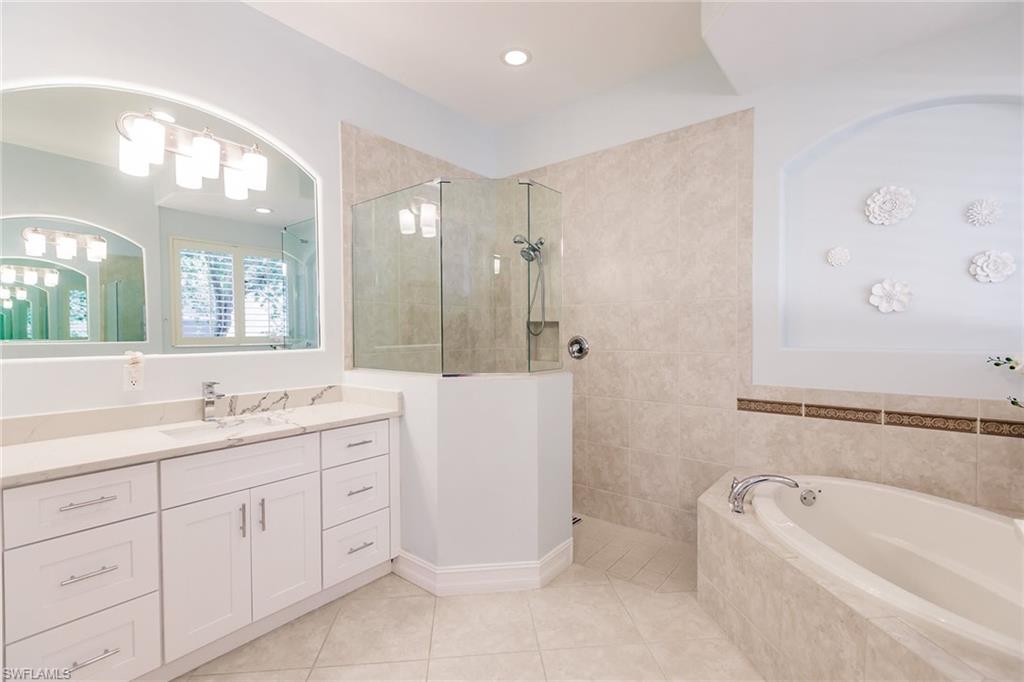 7797 Ashton Road Naples, FL 34113 - Photo 22 of 50 a bathroom with a tub a sink and mirror