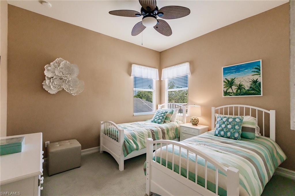 7797 Ashton Road Naples, FL 34113 - Photo 23 of 50 a bedroom with two beds and a chandelier