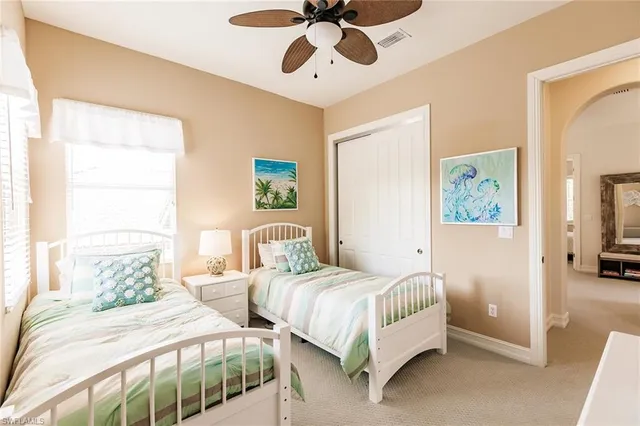 a bedroom with two beds and painting on the wall
