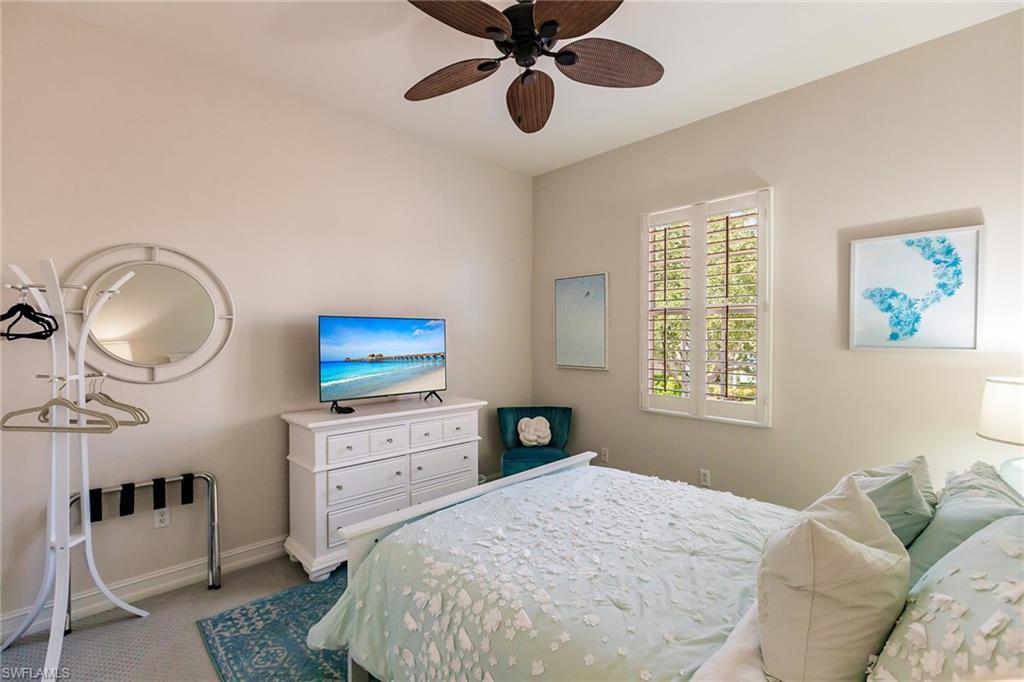 7797 Ashton Road Naples, FL 34113 - Photo 29 of 50 a bedroom with a bed and a chandelier