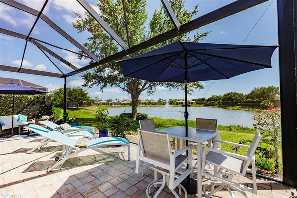 a view of a patio with a table chairs and a backyard