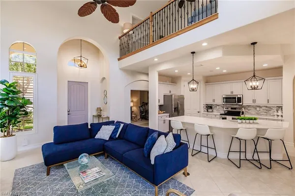 a living room with furniture kitchen view and a chandelier