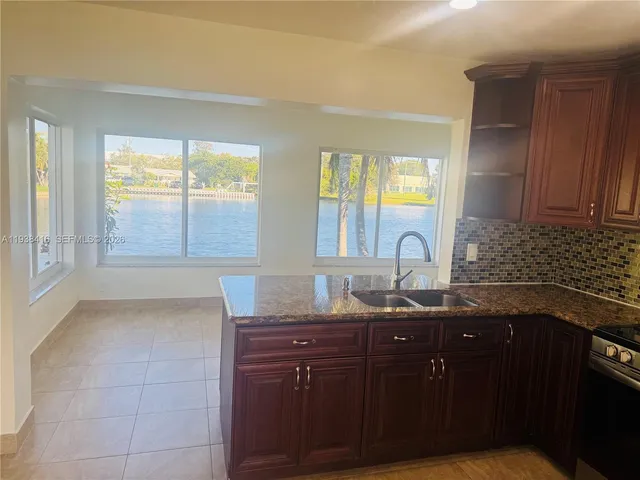 a kitchen with granite countertop a sink and a stove