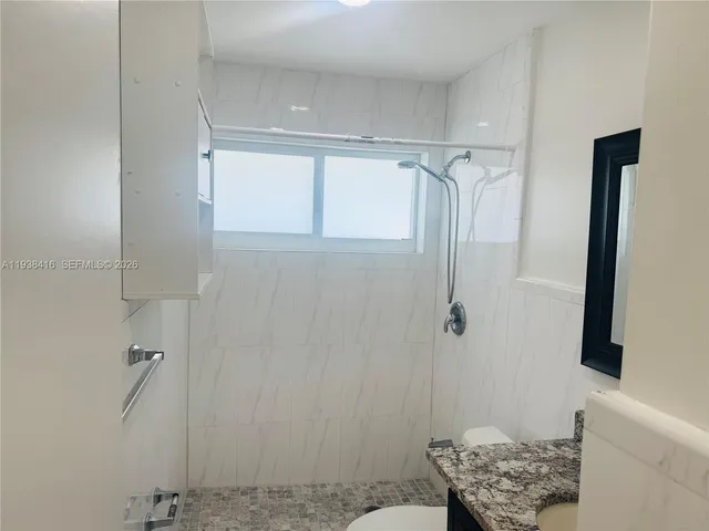 a bathroom with a granite countertop shower and a sink
