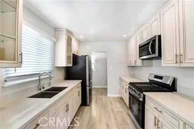a kitchen with stainless steel appliances a stove sink microwave and refrigerator