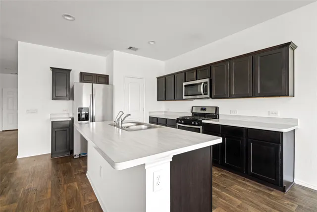 a kitchen with stainless steel appliances granite countertop a sink stove microwave and refrigerator