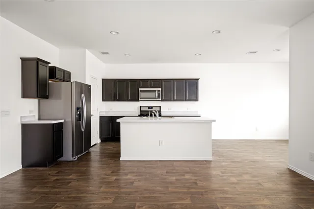 a view of kitchen with refrigerator stove microwave and cabinets