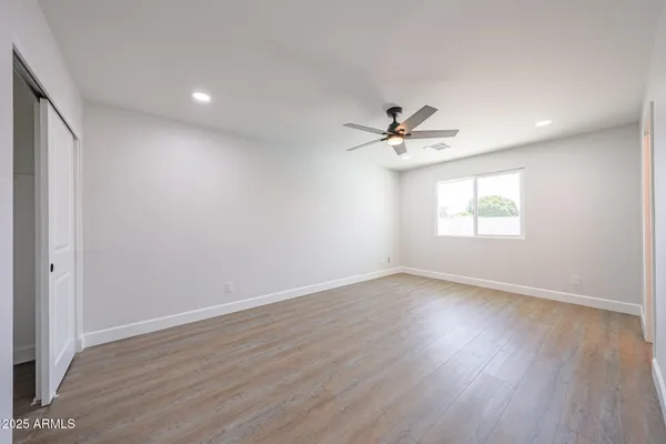 a spacious bedroom with a bed a window and a chandelier