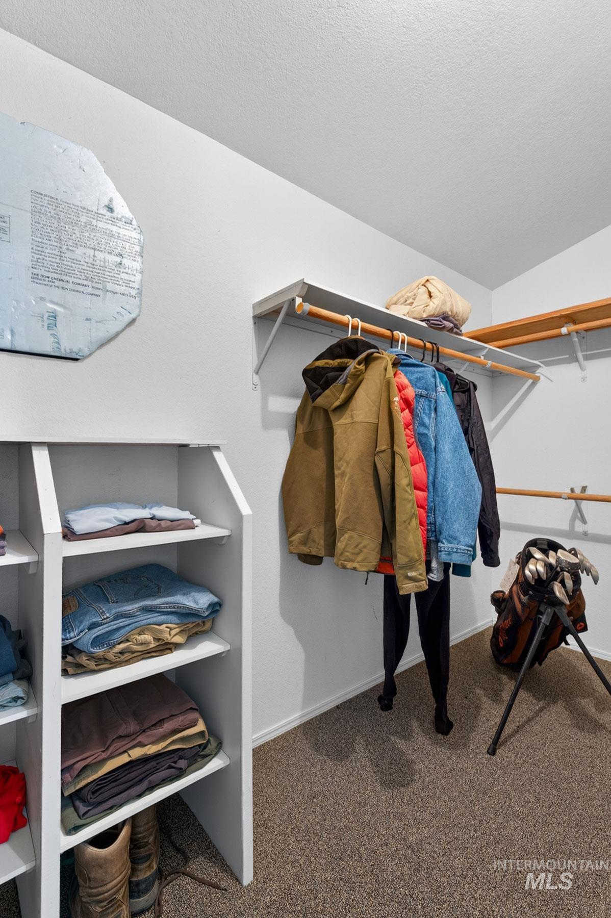 151 Cow Creek Road Lucile, ID 83542 - Photo 23 of 50 Organized closet space featuring built-in shelving, two levels of hanging rods, and textured carpeting