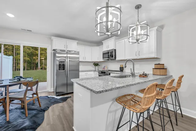 a view of a dining room with furniture a chandelier and wooden floor