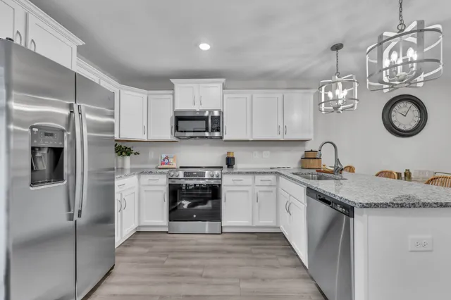 a kitchen with stainless steel appliances granite countertop a stove a sink and a refrigerator