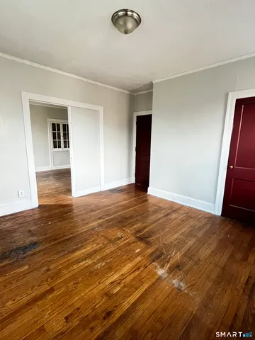 a view of an empty room with wooden floor