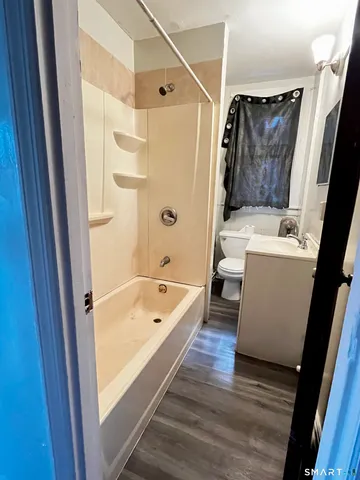 a bathroom with a tub a sink and a shower